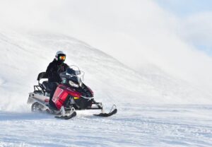 person on a snowmobile riding through snow in Colorado